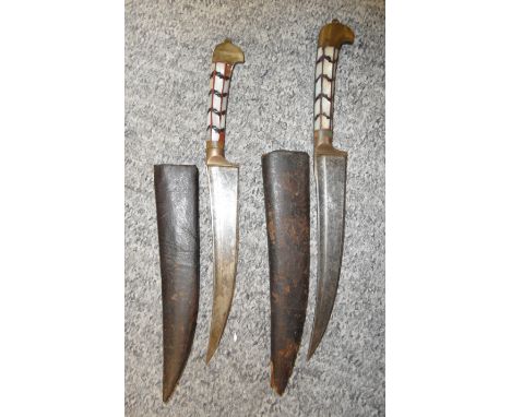 TWO INDIAN DAGGERS, EARLY 20TH CENTURY each with curved fullered blade, brass ferrule extending along the back-piece, brass b