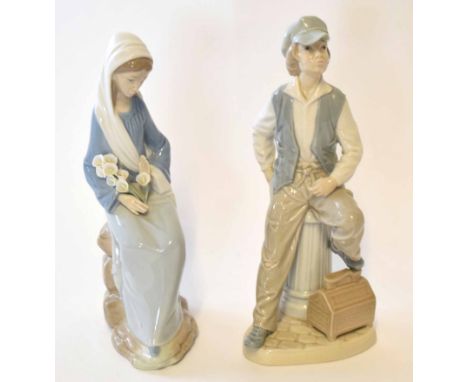 Two Lladro or Nao Spanish porcelain figures, one of a young boy, the other of a young girl, the boy 25cm high 