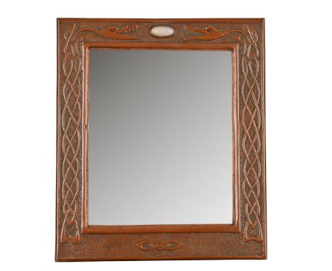 SCOTTISH SCHOOL CELTIC REVIVAL COPPER WALL MIRROR, CIRCA 1900the bevelled plate within repoussé-decorated frame set with opal