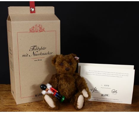 Steiff (Germany) EAN 037955 teddy bear with nutcracker, trademark Steiff button to ear with red and white tag, 26cm high, box