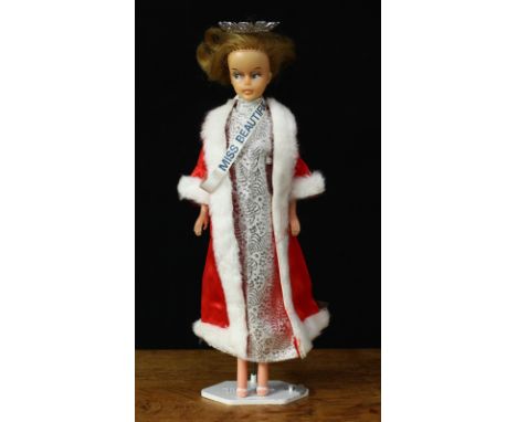 A 1960's Palitoy Tressy doll, mid blonde hair, side glancing blue eyes, wearing a beauty pageant outfit with "MISS BEAUTIFUL"