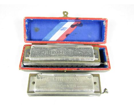 A boxed Hohner The Super Chromonica chromatic harmonica together with one other