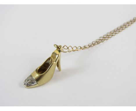 A novelty yellow metal pendant in the form of a stiletto with diamond chipped toe, marked 9ct, on a fine curb link neck chain