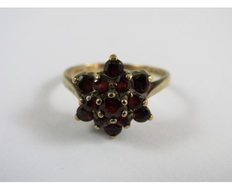 A vintage 9ct gold and garnet flower head cluster dress ring