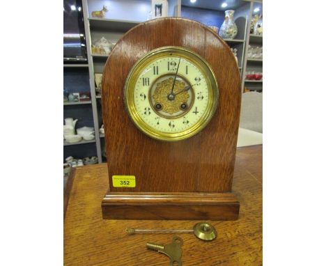 A D Mougin oak cased mantel clock with cream Arabic enamelled dial, the centre with gilt pierced design, twin winding holes, 