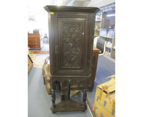 A Victorian pussy oak corner cabinet having a carved panelled door with single shelf below 73 1/4"h X 31 1/4" w 