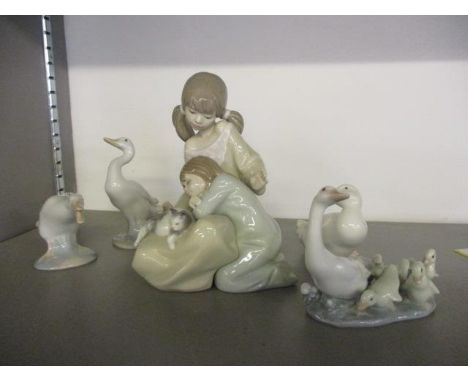 A Lladro figurine of two children playing with a cat, and two other Lladro and Nao models of geese 