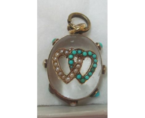 A glass pendant with pearl and turquoise double heart and border