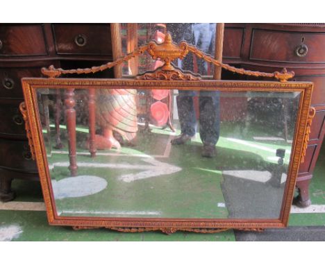 A gilt bevelled wall mirror with urn and swag to top