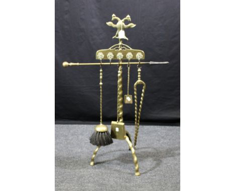 An early 20th century cast brass companion stand, with twin head spread eagle finial over five lion's mask hooks suspending b