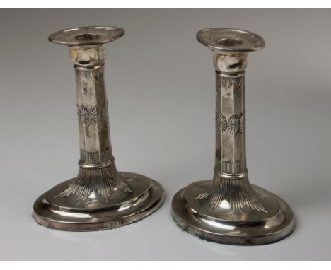 George Howson, a pair of silver table candlesticks, each having detachable oval sconce, stylised floral and fluted octagonal 