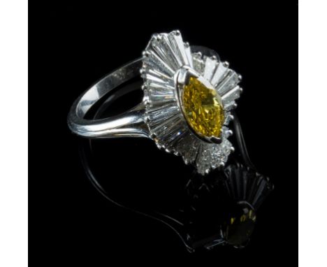 A canary yellow and colourless diamond dress ring, the marquise shaped canary yellow diamond in raised mount, above a border 