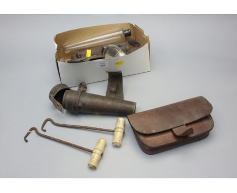 A collection of vintage hunting items, including saddle sandwich box and conical stirrup flask