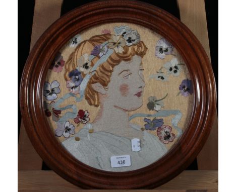 A late 19th/early 20th century long and short stitch silkwork, a head and shoulders portrait of a young woman with ribbon and