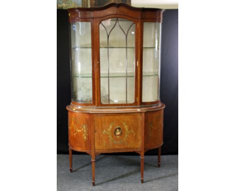 An Edwardian mahogany, boxwood strung and florally painted break bow fronted vitrine, the stepped swept cornice over a ribbon