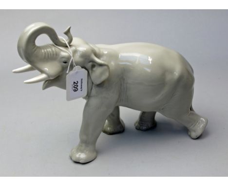 A mid 20th century Russian ceramic model of a bull elephant trumpeting and walking, grey gloss glazed, red printed mark, 22 x