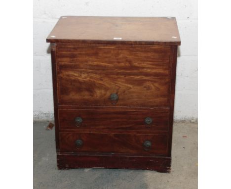 An early 19th  century mahogany commode chest, having a double hinged rising top over two false drawers, each with florally c