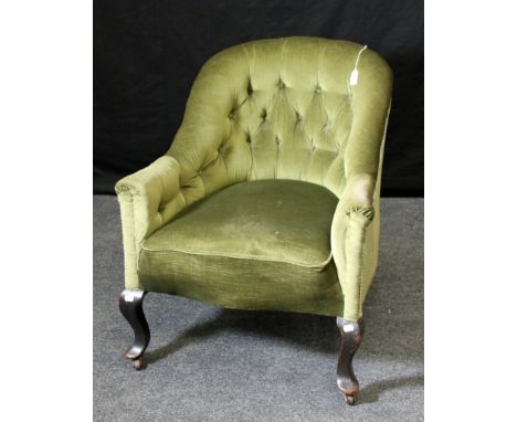 An Edwardian green button velour upholstered tub shape nursing armchair on ebonised cabriole forelegs