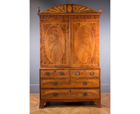 A George III Sheraton design figured mahogany and parquetry inlaid linen press with arched cresting above a pair of decorativ