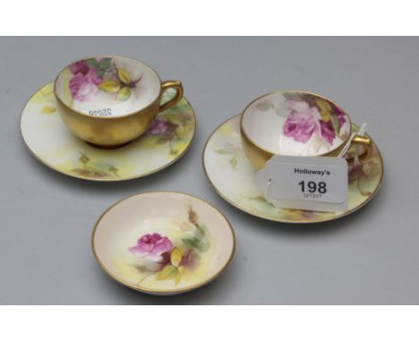 A pair of Royal Worcester cabinet tea cups and saucers, each painted with pink roses and foliage on an ivory ground, together