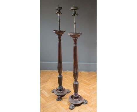 A pair of part 18th century mahogany standard lamp (bed posts) with carved decoration, raised on a turned disc base with lion