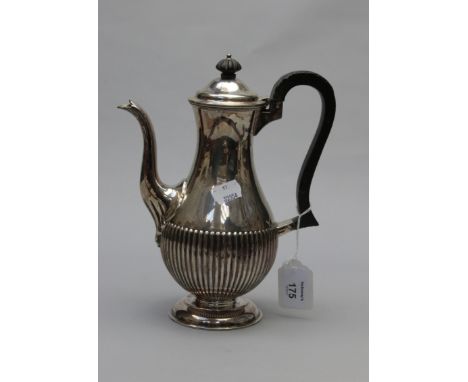 Edward Hutton, a silver coffee pot of demi reeded form, with ebony knop and leaf carved scroll handle on stepped circular foo