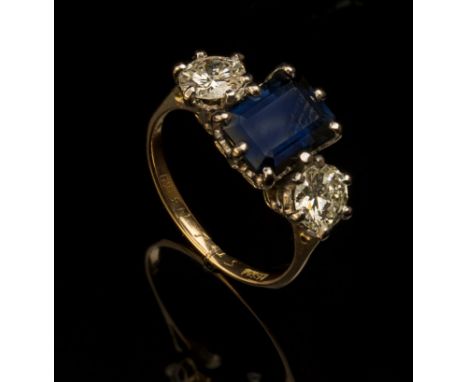 A sapphire and diamond three stone half hoop ring, the central step-cut sapphire flanked by brilliant cut diamonds, all claw 