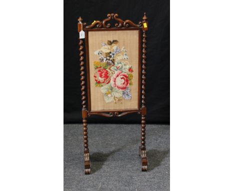 A Victorian mahogany firescreen, the scrolled, barley twist and bobbin turned frame enclosing a gros point and beadwork flora