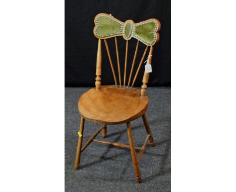 An Edwardian birch child's chair, having a close studded green plush upholstered 'butterfly' rail, stick back, shaped circula