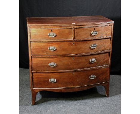 A George III mahogany bow front chest of two short over three long drawers, raised on shaped bracket feet