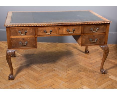 An Edwardian mahogany desk, in the manner of Chippendale, the crossbanded rectangular top with gadrooned edge, set with green