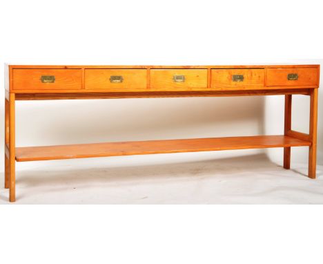 A 20th Century pine wood campaign style long hall table / console table having a four drawer sideboard top with brass recesse