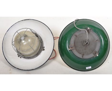 A pair of retro vintage 1930's industrial factory pendant light lamp shades having a green enamel finish with white enamel in