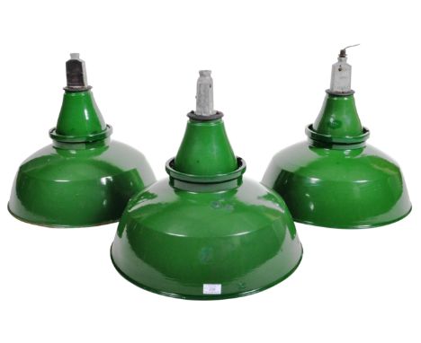 A set of three retro vintage 1960's industrial factory pendant shades having a green enamel finish with white enamel interior