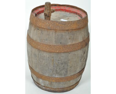 A vintage 20th Century oak and iron bound barrel of typical form having four iron bands and embossed plaque atop. Wear commen