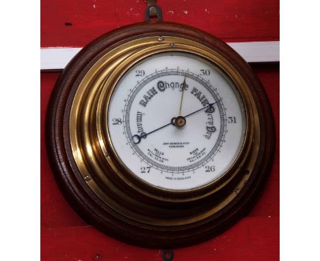 Early 20th century brass cased aneroid barometer mounted on turned oak backing to a drum shaped case with spun bezel enclosin