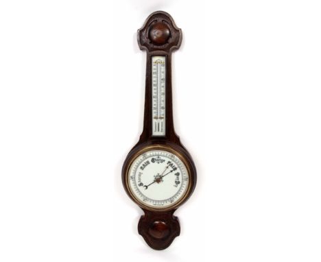 Early 20th century oak cased aneroid wheel barometer, the carved case set with a twin-scale ceramic mercury thermometer to a 