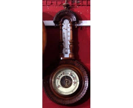 Late 19th century walnut cased aneroid wheel barometer, carved and shaped case set with an opaque glass backed mercury twin-s