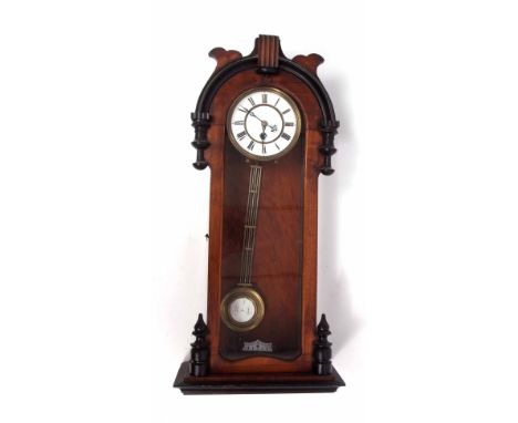 Late 19th century walnut and ebonised Vienna type timepiece, the rounded and shaped pediment to a glazed and hinged door and 