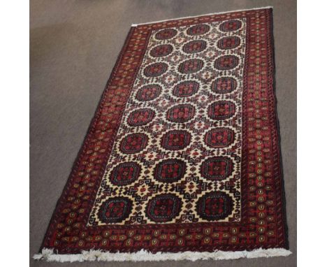 Caucasian carpet with central panel of geometric lozenges within a triple gulled border, red and beige field, 110 x 204cm  