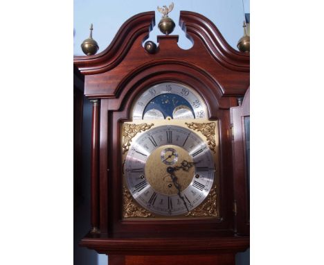 Modern mahogany cased triple weight driven longcase clock with moon phases, the break arch pediment with overhanging cornice 