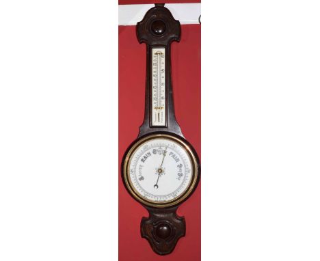 Early 20th century carved oak aneroid barometer with twin scale porcelain backed mercury thermometer to a sprung bezel with a