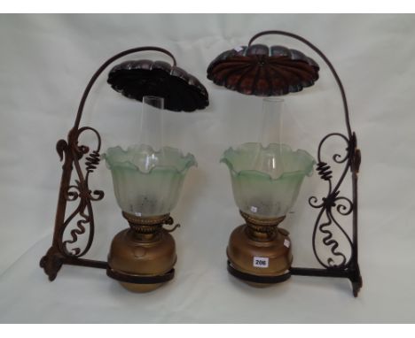 Pr. Of Arts & Crafts Wrought iron bracket framed brass reservoir oil lamps with signed shades 'Jaime' over