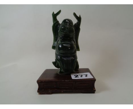 Spinach Green Jade figure of a Budda with outstretched arms mounted on wooden base