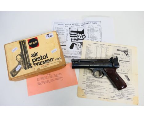 A 0.22 over barrel spring air pistol "Webley Premier model" in its original box. The box has instructions for use on the inne