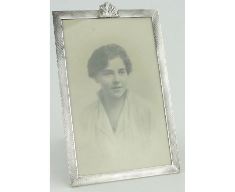 A large engine turned silver photo frame of rectangular form,
with acanthus leaf pediment, Birmingham 1929, 29.5cm x 19.5cm.