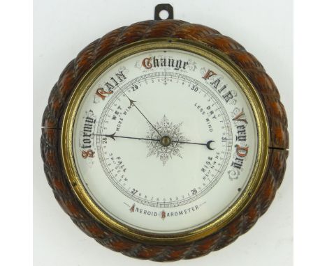 A Victorian aneroid wall barometer,
in carved oak ropetwist surround, 11" across.