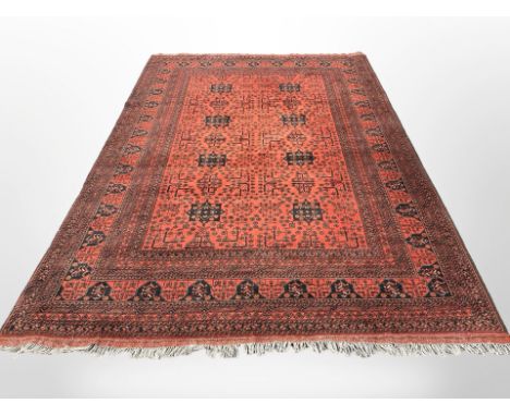 A Turkoman carpet, Afghanistan, the eight black medallions within a floral madder field, enclosed by matching borders and thi