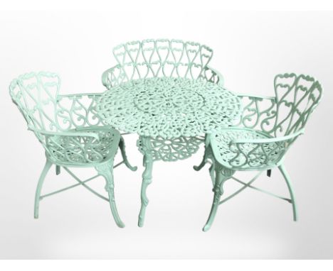 A painted cast iron garden patio table, diameter 80 cm and a matching pair of armchairs and small bench 