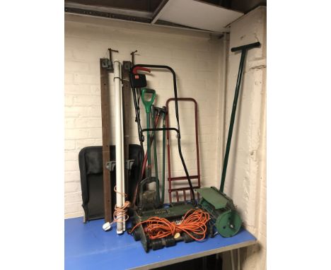 A Black & Decker electric garden mower, a push-along garden scarifier, various garden tools, two clamps, etc.